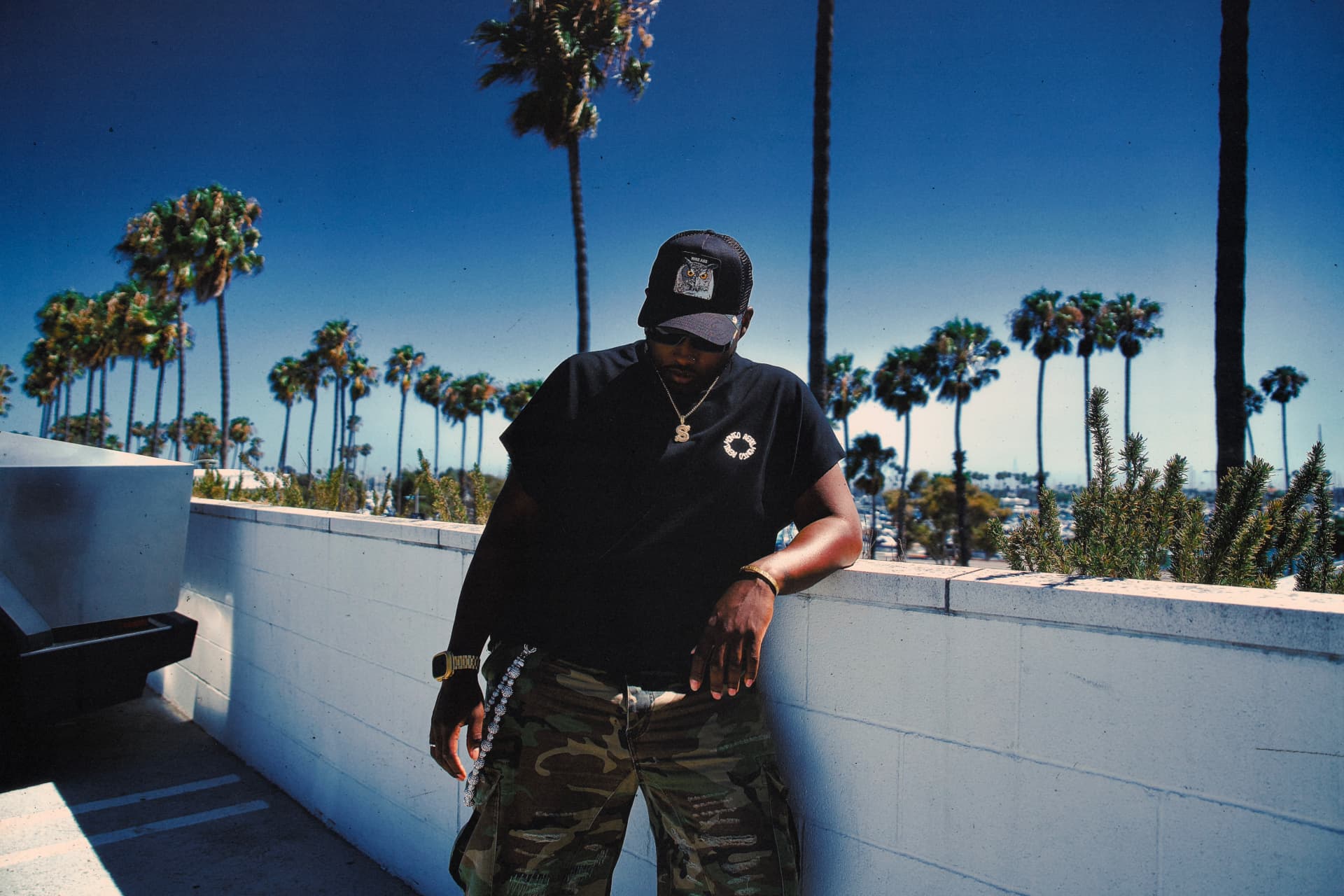 Sali photographed on a Long Beach rooftop against palm trees and a deep blue sky
